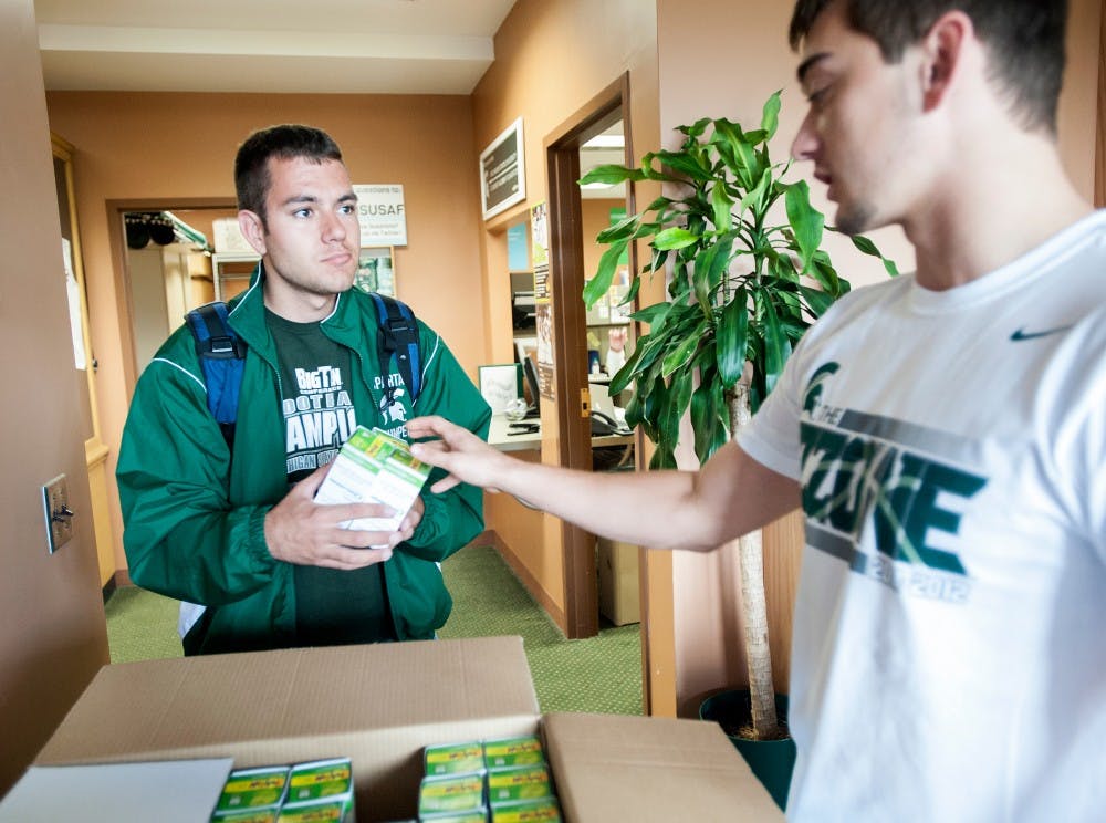 	<p>Physiology junior Daniel Aaron receives green light bulbs from physiology junior Jason Unold, who works at Student Alumni Foundation on Monday, Oct. 1, 2012 at <span class="caps">MSU</span> Union. <span class="caps">SAF</span> is giving away free light bulbs ahead of Homecoming. Justin Wan/The State News</p>