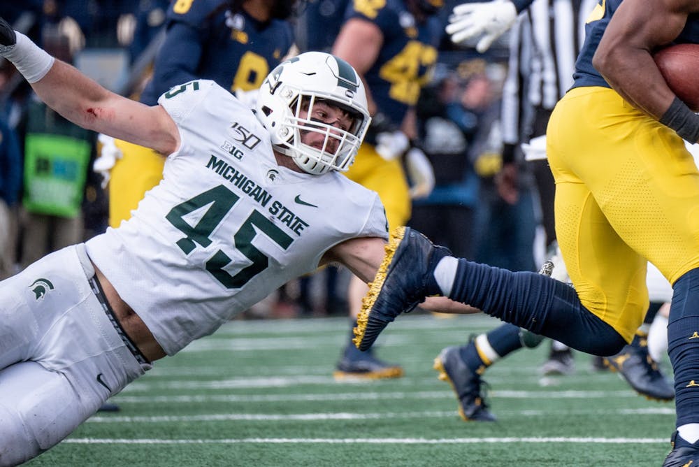 <p>Sophomore linebacker Noah Harvey (45) dives for a tackle during the game against Michigan on Nov. 16, 2019 at Michigan Stadium. The Spartans fell to the Wolverines, 44-10.</p>