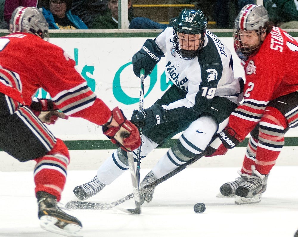 	<p>Freshman forward Matt DeBlouw tries to advance the puck with Ohio State defenseman Curtis Gedig, No. 8, and forward Travis Statchuk in defense. The Buckeyes defeated the Spartans 3-1 Saturday, Dec. 1, 2012, at Munn Ice Arena. Justin Wan/The State News</p>