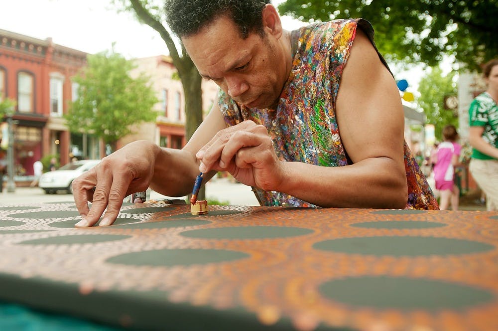 	<p>Lansing resident Brian Snyder works on his art at the corner of Grand River Avenue and Turner Street on June 1, 2013. With the purchase of a passport, eventgoers were allowed to do many free events in the Lansing area. Weston Brooks/The State News</p>