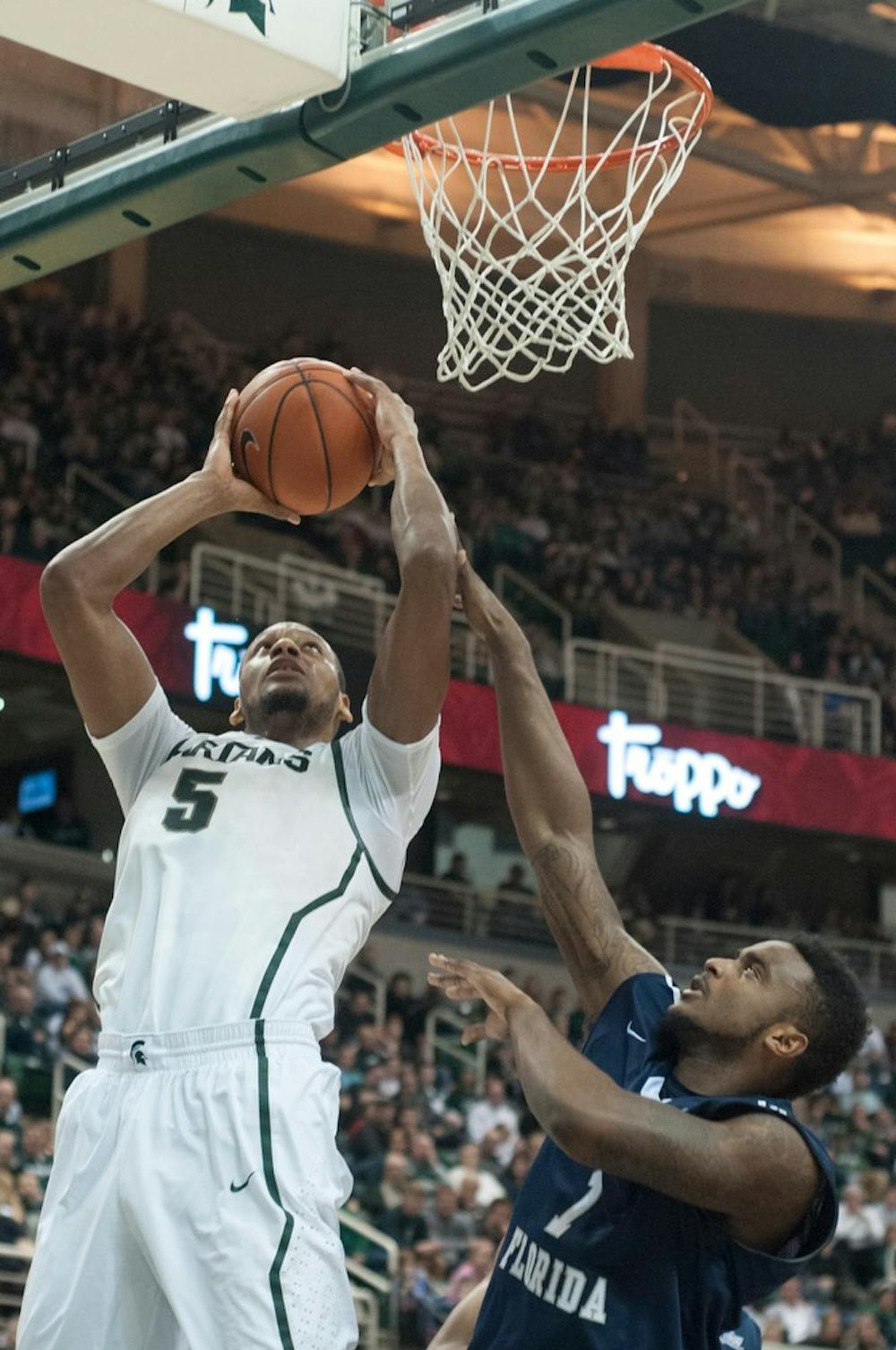 	<p>Senior center Adreian Payne goes up to the basket as University of North Florida forward Travis Wallace defends Dec. 17, 2013, at Breslin Center. The Spartans won 78-48. Julia Nagy/The State News</p>