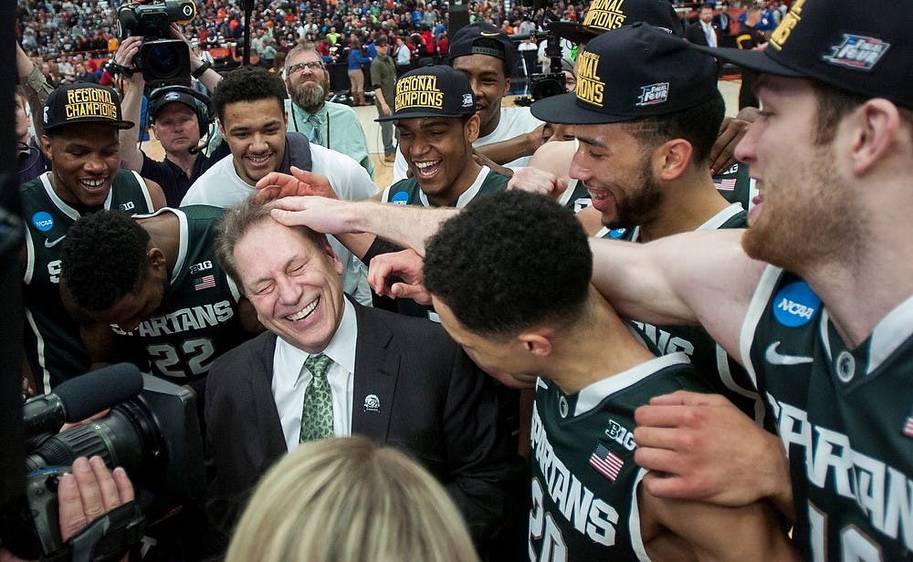 <p>Head coach Tom Izzo and his team celebrate the win March 29, 2015, during the East Regional round of the NCAA Tournament in the Elite Eight against Louisville at the Carrier Dome in Syracuse, New York. The Spartans defeated the Cardinals, 76-70.</p>