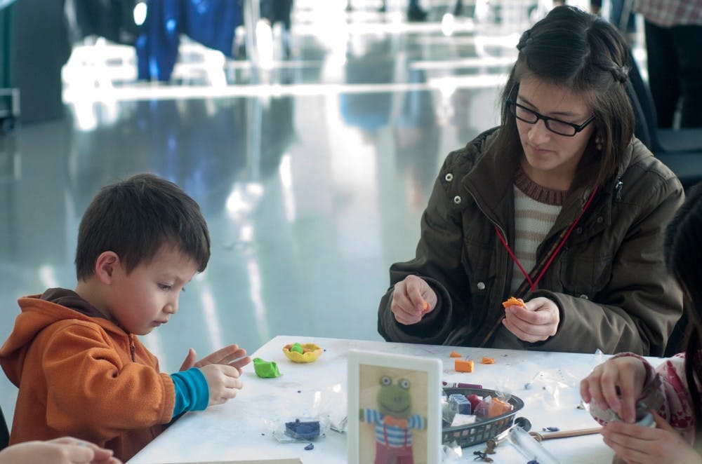 From left to right, Neo Liang, 5, and East Lansing resident Diana Liang make crafts during family day on Feb. 6, 2016 at the Eli and Edythe Broad Art Museum.