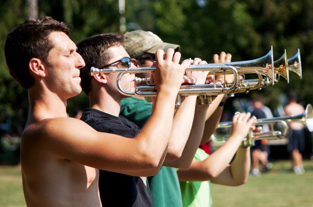 Senior communications major Adam Newton (left) practices with members of his rank at Dem Field on Thursday Aug. 30. The Spartan Marching Band practices Monday through Friday at Dem Field and will debut at the Michigan State v. Boise State game on Friday night. Griffin Zotter/The State News