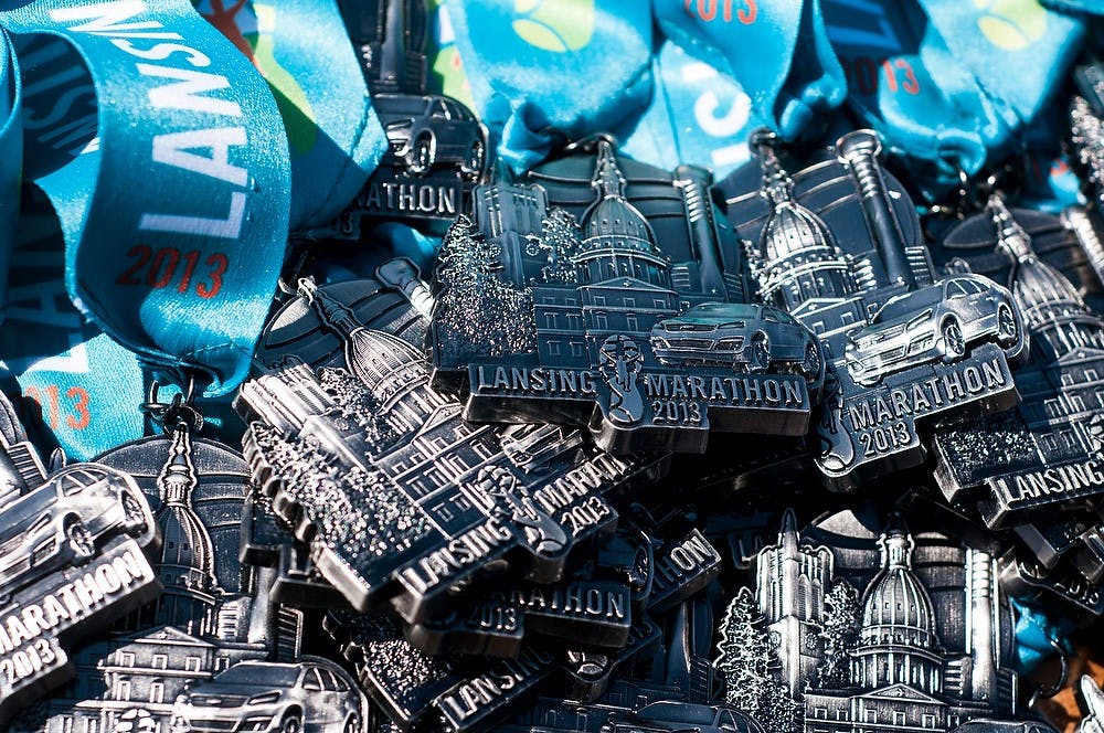 	<p>Medals for participants of the Lansing Marathon sit on a table by the finish line during the Lansing Marathon Sunday on Michigan Avenue. This was the first national marathon since the April 15, 2013 Boston Marathon. Katie Stiefel/The State News</p>