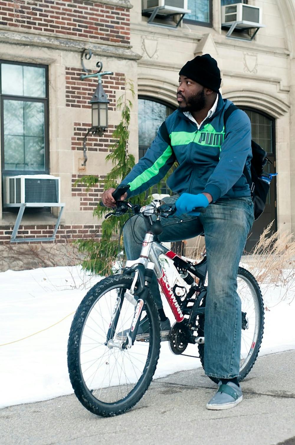 <p>Graduate student Shingi Mavima pauses on his bike Jan. 15, 2015, in front of the Human Ecology Building. He says he prefers to ride his bike around campus because it is a more accessible form of transportation and a great form of exercise. Allyson Telgenhof/The State News.</p>