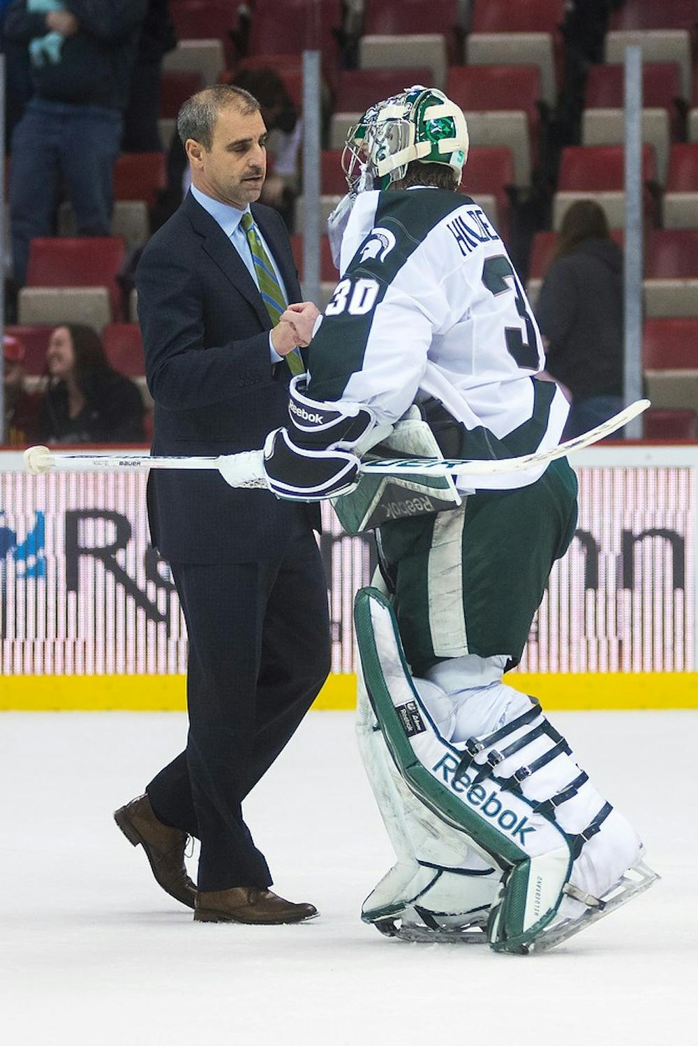 <p>Head coach Tom Anastos bumps fists with junior goaltender Jake Hildebrand following a win against Ferris State on Dec. 28, 2014, during the 50th Great Lakes Invitational at Joe Louis Arena in Detroit. Hildebrand stopped 31 shots, his first season shutout. Danyelle Morrow/The State News</p>