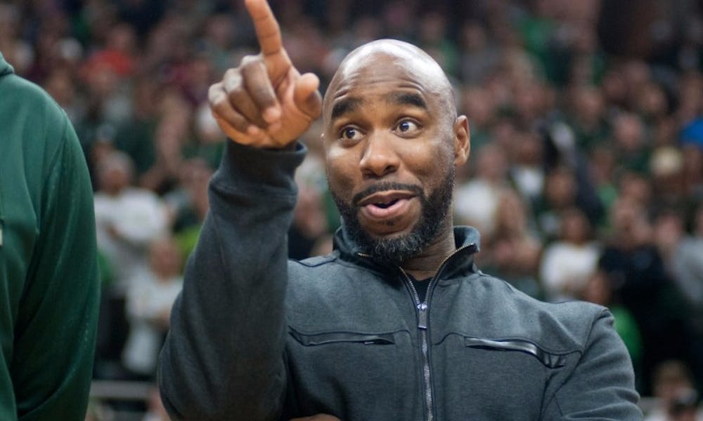 <p>Former men's basketball player Mateen Cleaves points to the crowd on Dec. 12, 2015 during the game against Florida at Breslin Center. The 2000 national champion MSU basketball team was honored at halftime. <strong>Photo by Julia Nagy</strong></p>