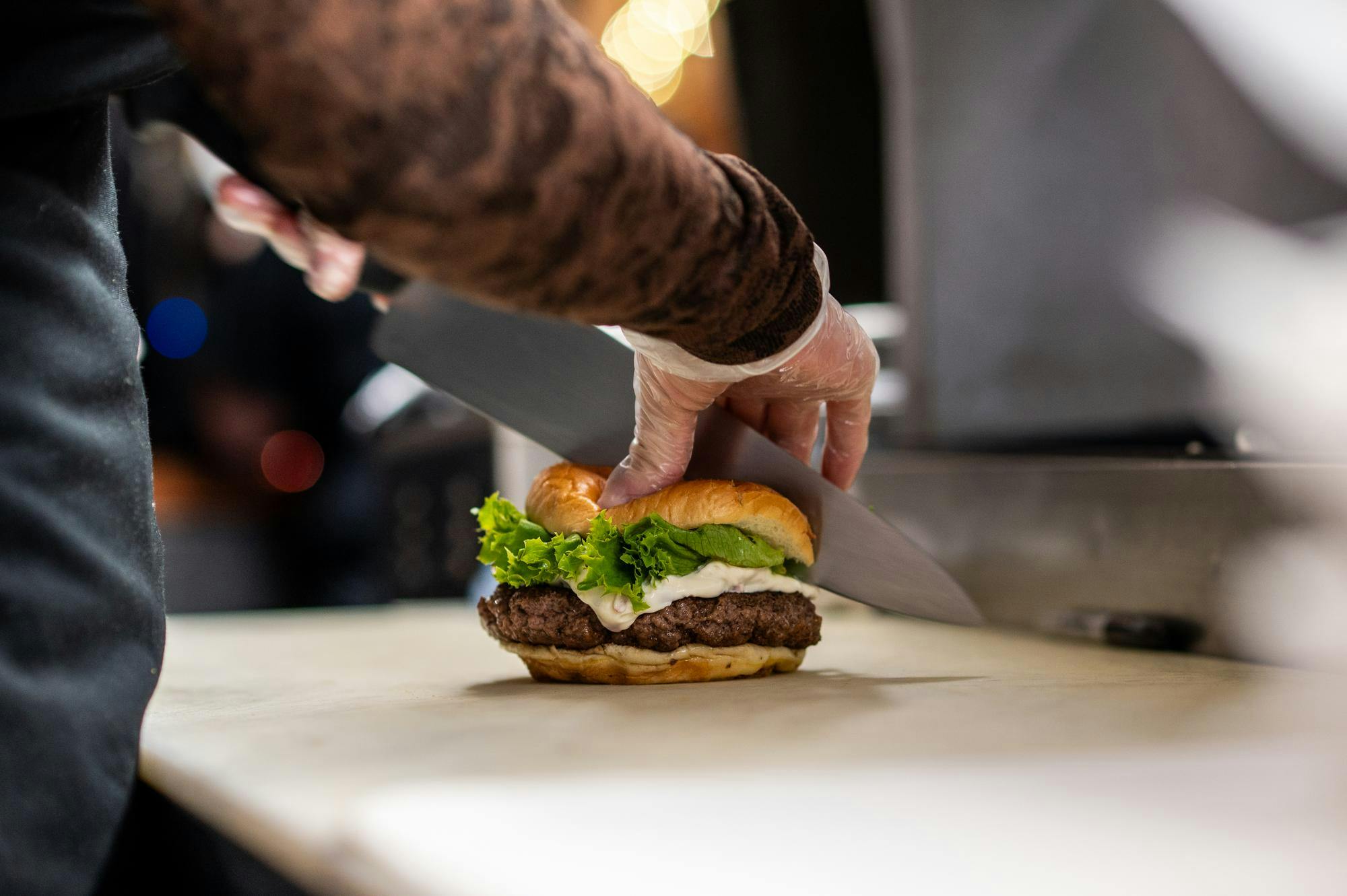 <p>Haley Wright, 23, of Arizona, assembles an olive burger while working at Kewpee Sandwich Shoppe in Lansing, Michigan, on Friday, Jan. 23, 2026.</p>