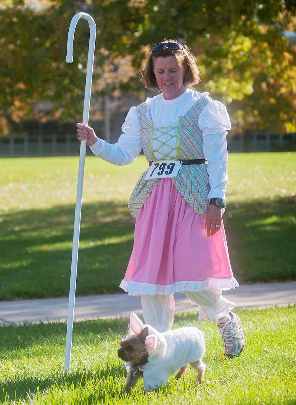 	<p>Williamston, Mich., resident Patty Kuptz walks with Bekeeni, a Yorkshire terrier on Nov. 3, 2013, by Fee Hall. The <span class="caps">MSU</span> Student Osteopathic Medical Association organized a 5k to fundraise for St. Baldrick and Cassie Hines foundations. Georgina De Moya / The State News</p>