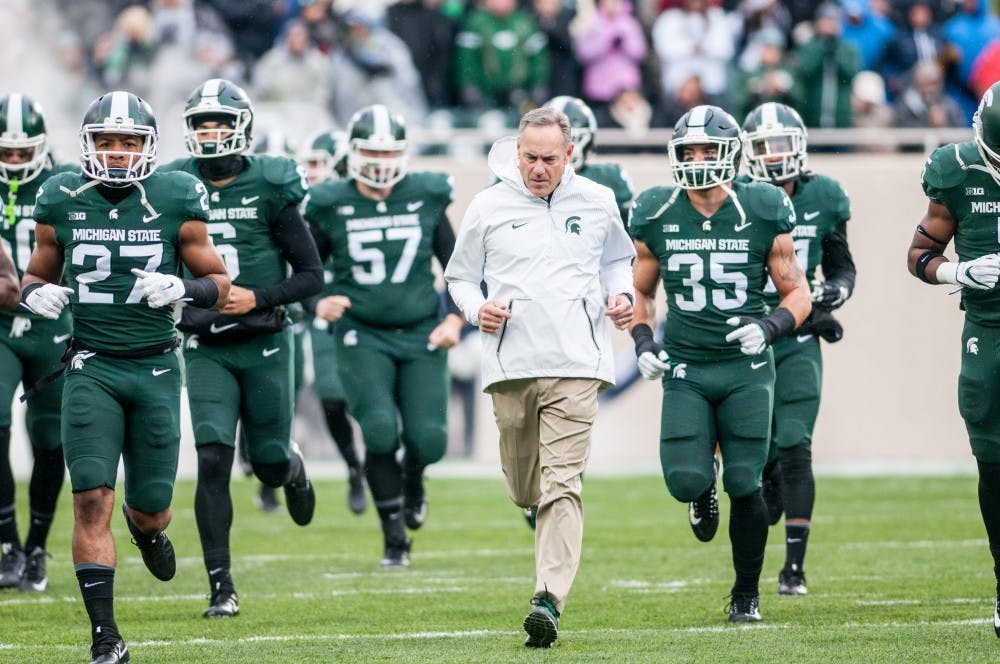 <p>Football head coach Mark Dantonio runs out onto the field before the game against Penn State, on Nov. 4, 2017, at Spartan Stadium. The Spartans defeated the Nittany Lions, 27-24.</p>