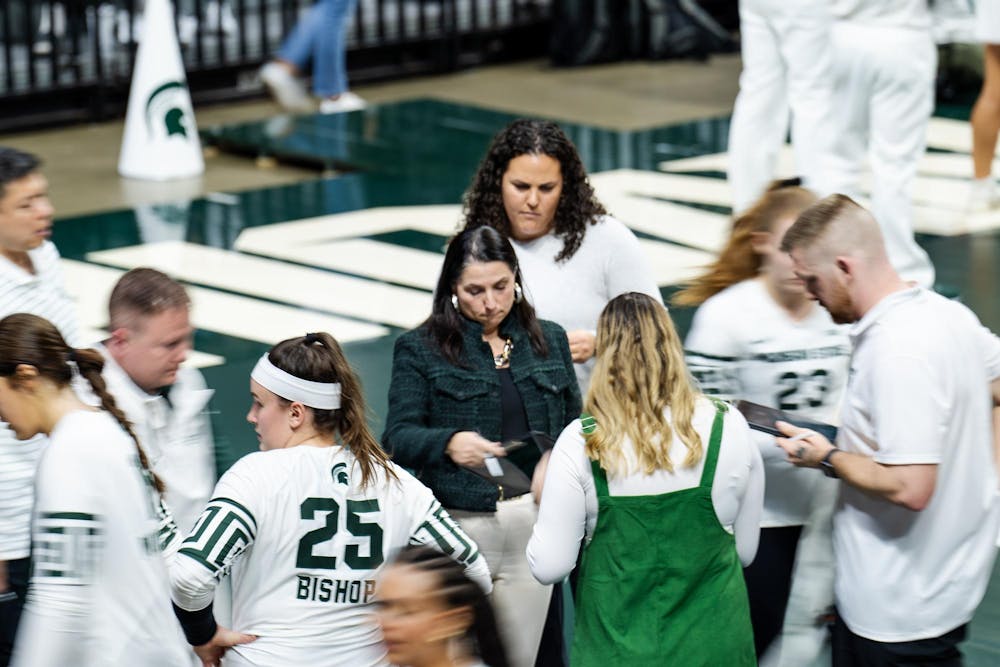 Michigan State head volleyball coach Leah Johnson reviews her notes during a timeout in the game against the University of Michigan at the Breslin Center on Nov. 15, 2024.