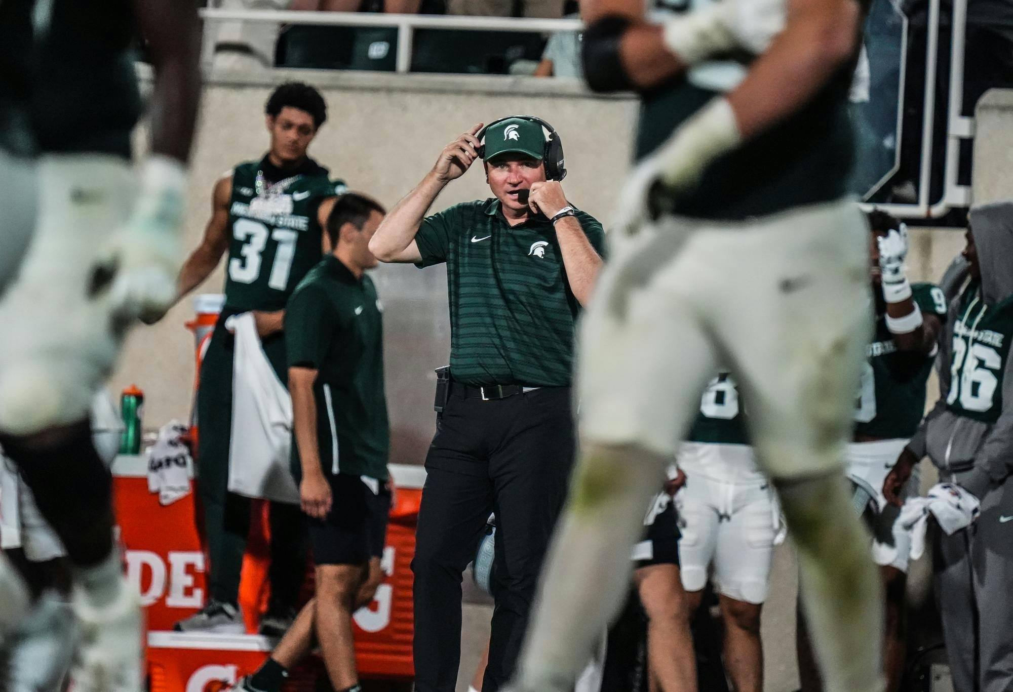 <p>Michigan State head coach Jonathan Smith adjusts his headset during his first game at Michigan State, ending with a 16-10 Spartan victory against Florida Atlantic at Spartan Stadium on Aug. 30, 2024.</p>