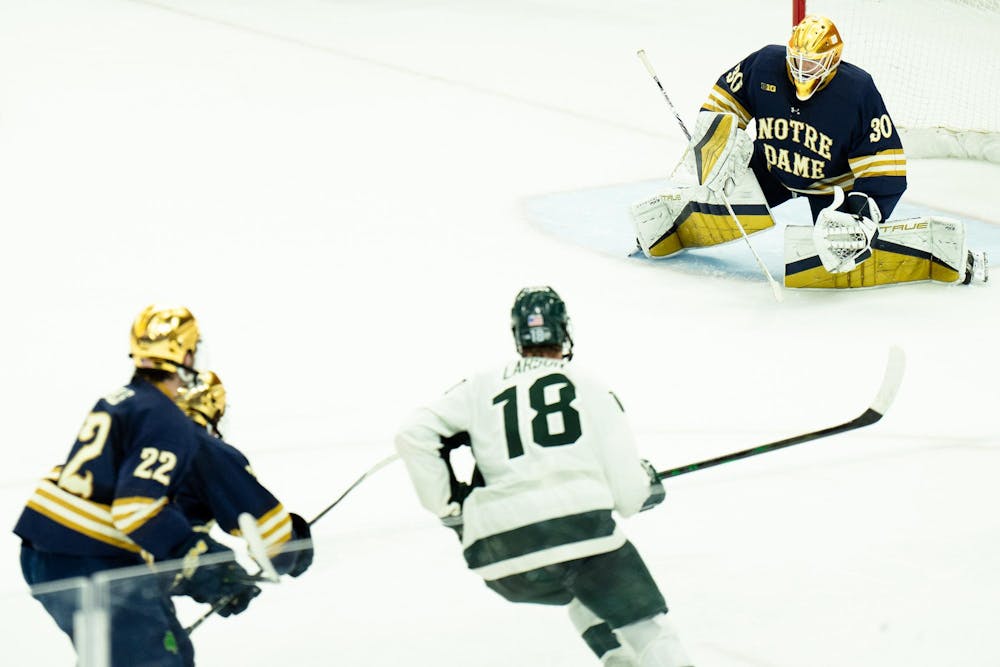 Notre Dame junior goaltender Owen Say (30) prepares to block his goal as players head his way at Munn Ice Arena on March 15, 2025. The Spartans took a 1-0 victory over the Fighting Irish, advancing to the Big Ten Championship.