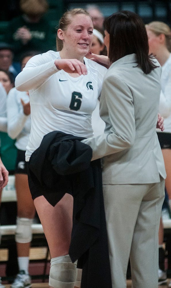 	<p>Senior outside hitter Amy Detlinger embraces head coach Cathy George after the game during senior night Wednesday, Nov. 21, 2012, at Jenison Field House. The Wolverines defeated the Spartans in three straight sets during senior night for the Spartans. Adam Toolin/The State News</p>