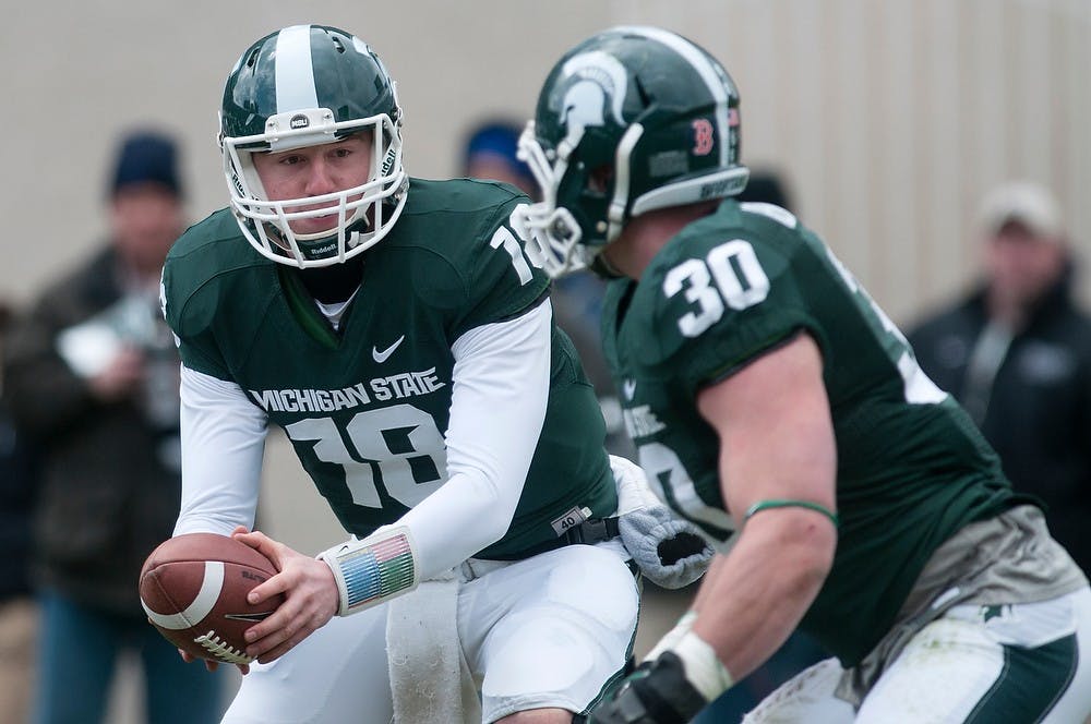 	<p>Sophomore quarterback Connor Cook hands the ball off to running back/linebacker Riley Bullough during the Green and White Spring Game on April 20, 2013, at Spartan Stadium. The White team won 24-17. Julia Nagy/The State News</p>