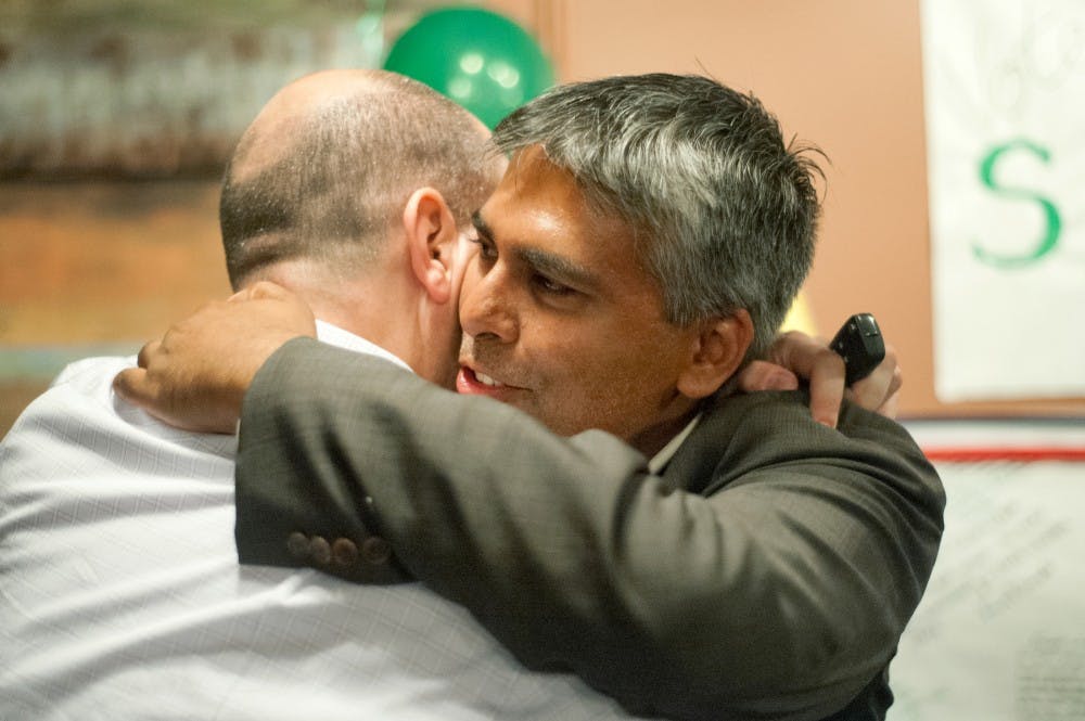 Sam Singh, right, embraces his former college roommate Michael Baird, of Southfield, Mich. after declaring victory of the primary election of the 69th district seat for the state House of Representatives Tuesday, Aug. 7, 2012 at Beggar's Banquet, of 218 Abbott Road. Justin Wan/The State News