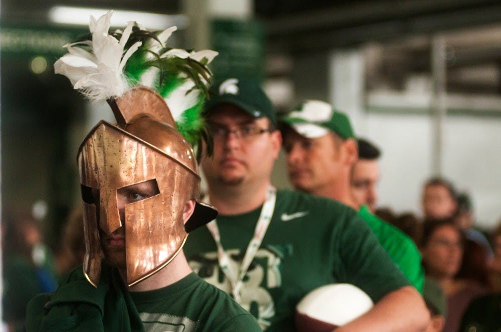 <p>Haslett, Mich., resident Sean Graff waits in line to receive head coach Mark Dantonio's signature on August 12, 2014, at Spartan Stadium. Meet the Spartans gave fans a chance to meet the football team before the season kicks off. Jessalyn Tamez/The State News</p>