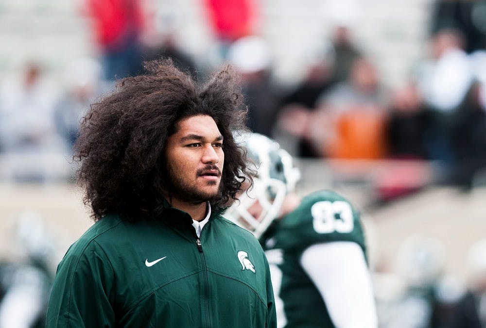 Senior offensive tackle Fou Fonoti watches his teammates warm up before the beginning of the game against Nebraska Nov. 3, 2012, at Spartan Stadium. Fonoti, who is out with a foot injury watched as the Spartans were defeated 28-24 by the Cornhuskers. Katie Stiefel/ State News