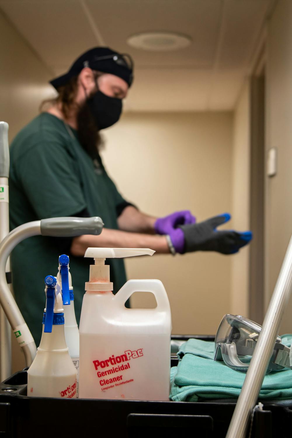 _______, who is a part of Olin Health Center's janitorial third shift,  cleans an exam room on Feb. 3, 2021.  
