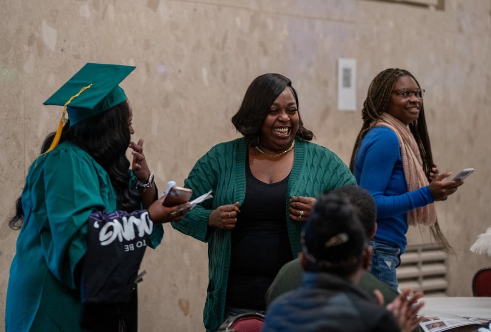 A family member and an MSU Fall 2023 graduate share a laugh before the start of the Fall 2023 Black Grad event at the Union Ballroom on Dec. 8, 2023. 