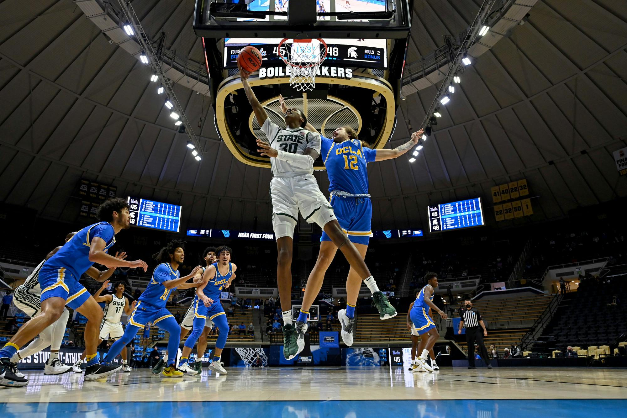 <p>WEST LAFAYETTE, IND. — MARCH 18: Marcus Bingham Jr. (30) of the Michigan State Spartans drives past Mac Etienne (12) of the UCLA Bruins in the First Four round of the 2021 NCAA Division I Men&#x27;s Basketball Tournament (Courtesy: NCAA Photos)</p>