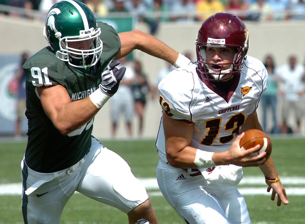 Central Michigan quarterback Dan LeFevour is chased down by MSU defensive end Tyler Hoover during Saturday's game. The Spartans lost to the Chippewas with a final score of 29-27. Chelsea Lee/State News.