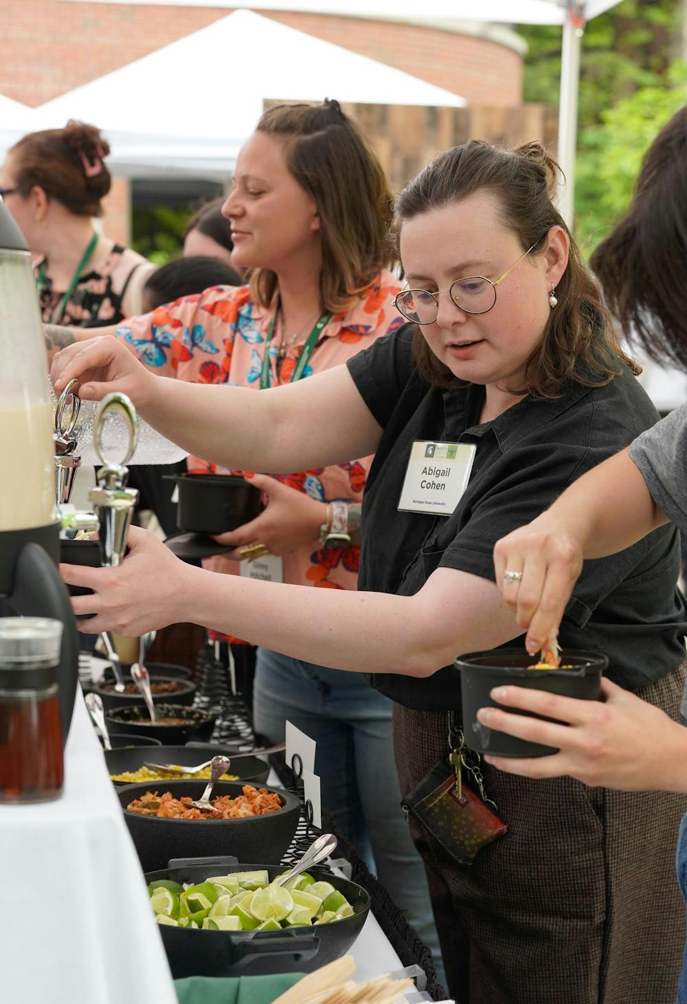 An attendee of the Excellence in Insect Science Symposium pours shiitake miso broth with cricket powder and whole crickets on May 16, 2024.