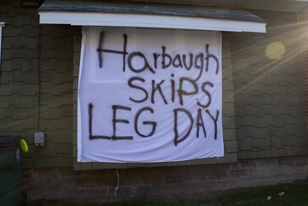 A bedsheet sign on an East Lansing house Oct. 31, 2020, reading "(Jim) Harbaugh skips leg day." 