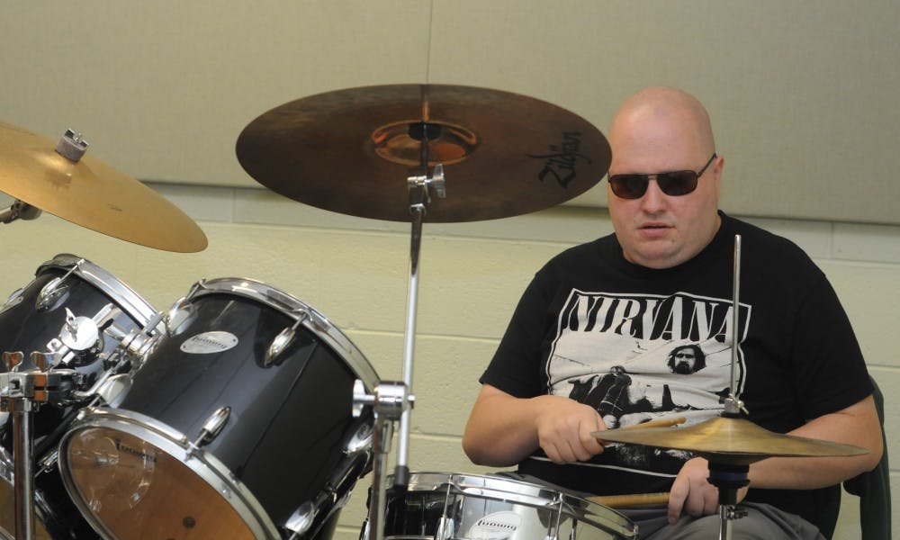 <p>Rock n'Roll combo member Adam Shepherd plays the drums on Oct. 12, 2015 inside the MSU Community Music School, 4930 South Hagadorn Road, in East Lansing. The MSU Community Music School's music therapy program is aimed at increasing motor, verbal, and social skills through music for students with special needs.</p>