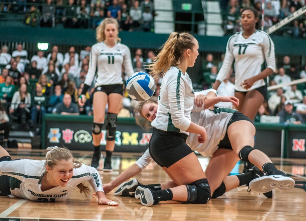 Freshman middle blocker Rebecka Poljan (21) has a laugh after diving to dig a ball during the game against Michigan on Nov. 17, 2018 at Jenison Fieldhouse. The Spartans lost to the Wolverines 3-1.