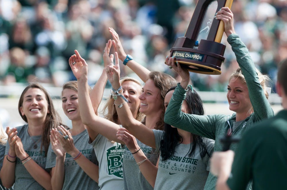 <p>Members of the MSU cross country women's team celebrate their national championship during a break in the game against Air Force on Sept. 19, 2015 at Spartan Stadium. The Spartans defeated the Falcons, 35-21. Kennedy Thatch/The State News</p>