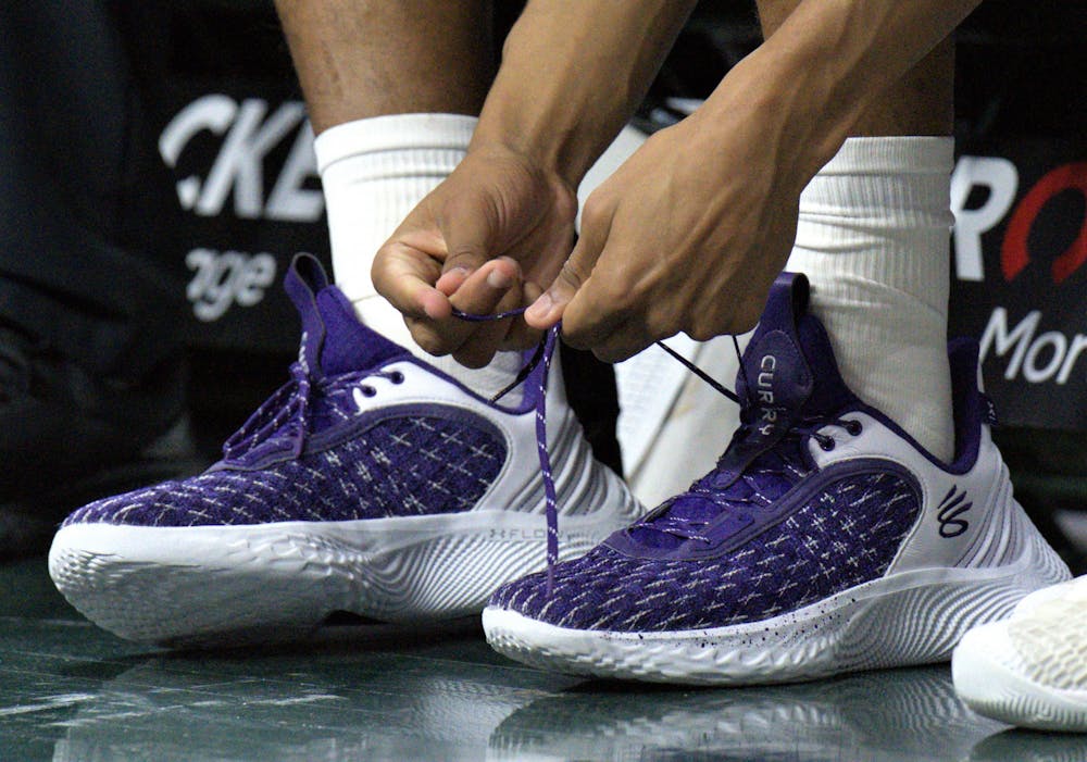 <p>A Northwestern Wildcat﻿ ties in shoe before the match against the Spartans at Breslin on Dec. 4, 2022. </p>