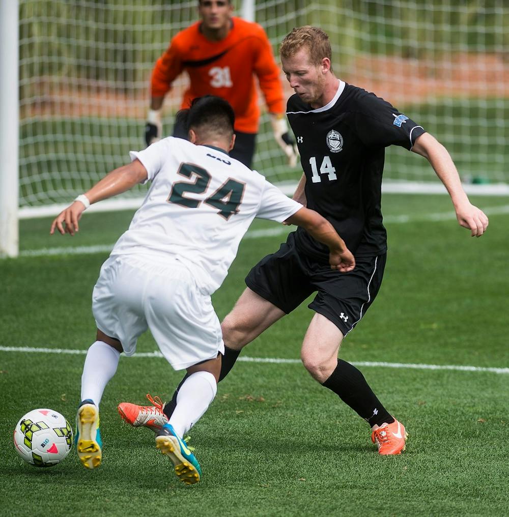 <p>Sophomore defender Jerome Cristobal attempts to score a goal past Stevens midfielder Jeff Althoff on Aug. 24, 2014, at DeMartin Soccer Stadium at Old College Field during a game against Stevens Institute of Technology. The Spartans defeated the Ducks, 4-0. Erin Hampton/The State News</p>