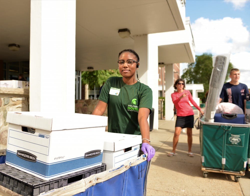 <p>Sophomore and Hall employee Jessica Williams helps new students move in for Fall move in day at South Hubbard Hall on Aug. 25, 2019.</p>