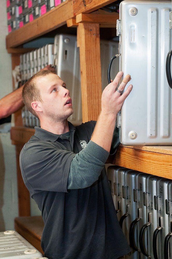 Lansing resident Eric Woods removes a voting booth on Nov. 5, 2012, at East Lansing City Hall, 410 Abbot Road. Woods was one of two movers who had the task of collecting all the voting materials and distributing them to the various precincts all throughout East Lansing. James Ristau/The State News