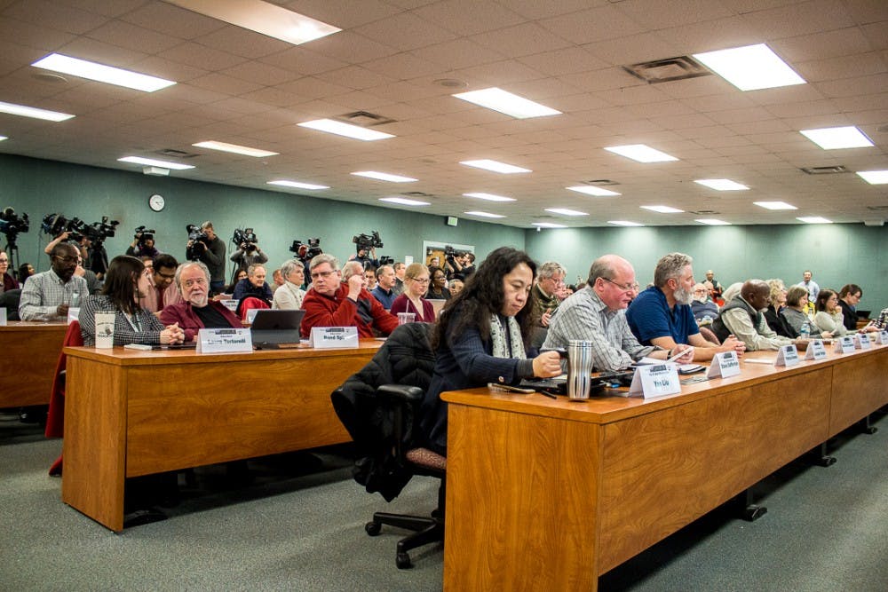 Faculty senate members vote during the meeting on Feb. 13, 2018 at the International Center. The faculty senate voted no confidence in the board. 