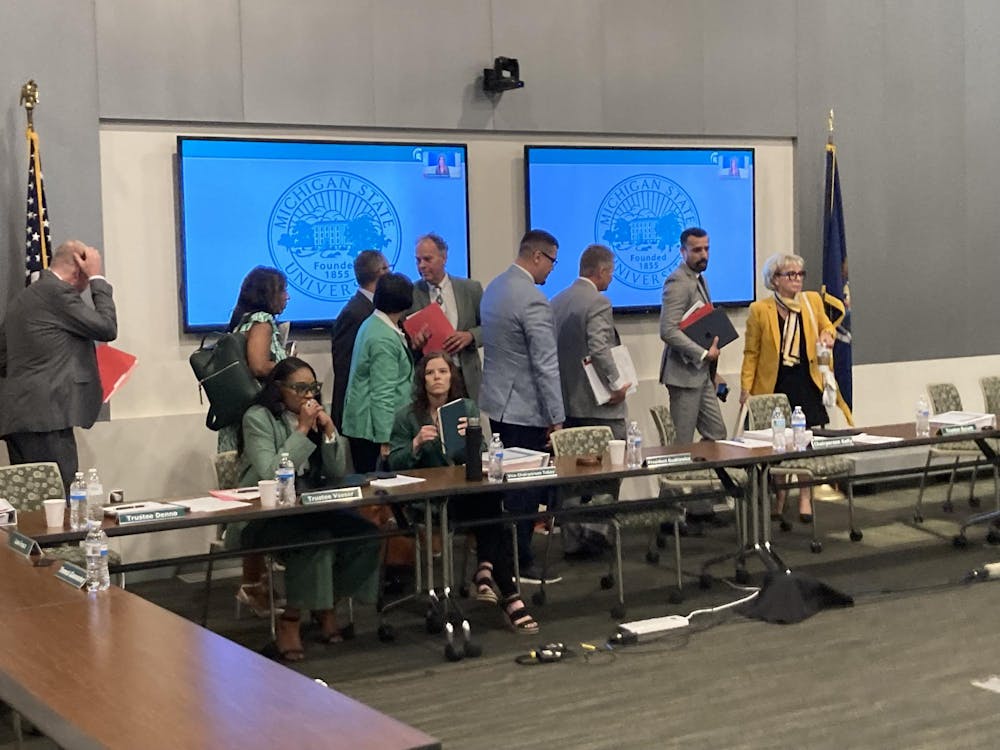 The Board of Trustees files out of the room during their Flint meeting when a divestment protest erupted. 