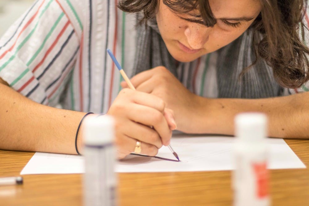 <p>Art history junior Liberty Fets paints some color into the lamp she drew at the Unity Painting event on Oct. 13, 2017, in Brody Hall. The &nbsp;event was hosted by the MSU Baha'i Association.</p>