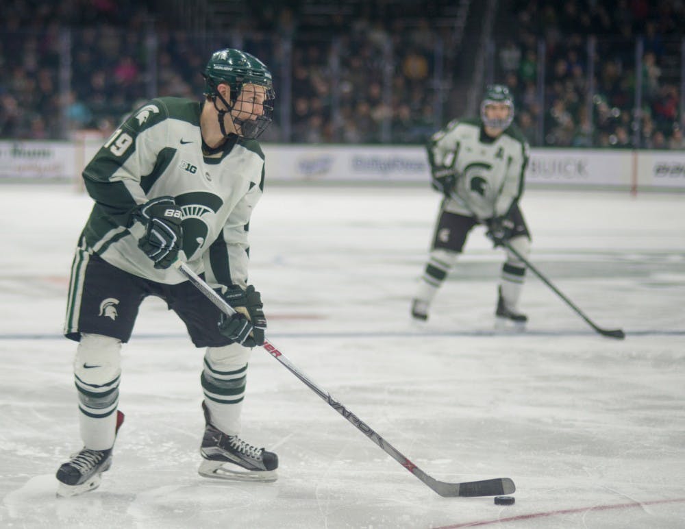 Senior forward Matt DeBlouw looks to pass the puck during the hockey game against Minnesota on March 4, 2016 at Munn Ice Arena. The Spartans were defeated by the Gophers, 4-2.