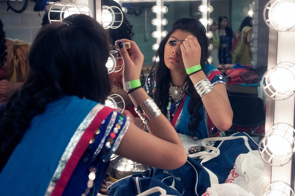 <p>Psychology freshman Anupama Rao puts on her make-up for the Satrang dance production April 5, 2014, held at the Wharton Center. The show consisted of 10 different Indian dance groups, a fashion show, and a musical performance by Spartan Sur. Allison Brooks/The State News</p>