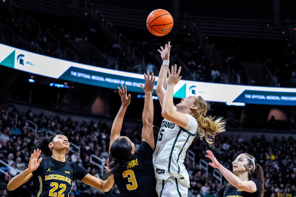 Michigan Wolverines guard Mila Holloway (3) and Michigan State Spartans guard Kennedy Blair (35) fight for ball during the women’s rivalry matchup at the Breslin Student Events Center in East Lansing, Mich., on Sunday, Feb. 1, 2026.