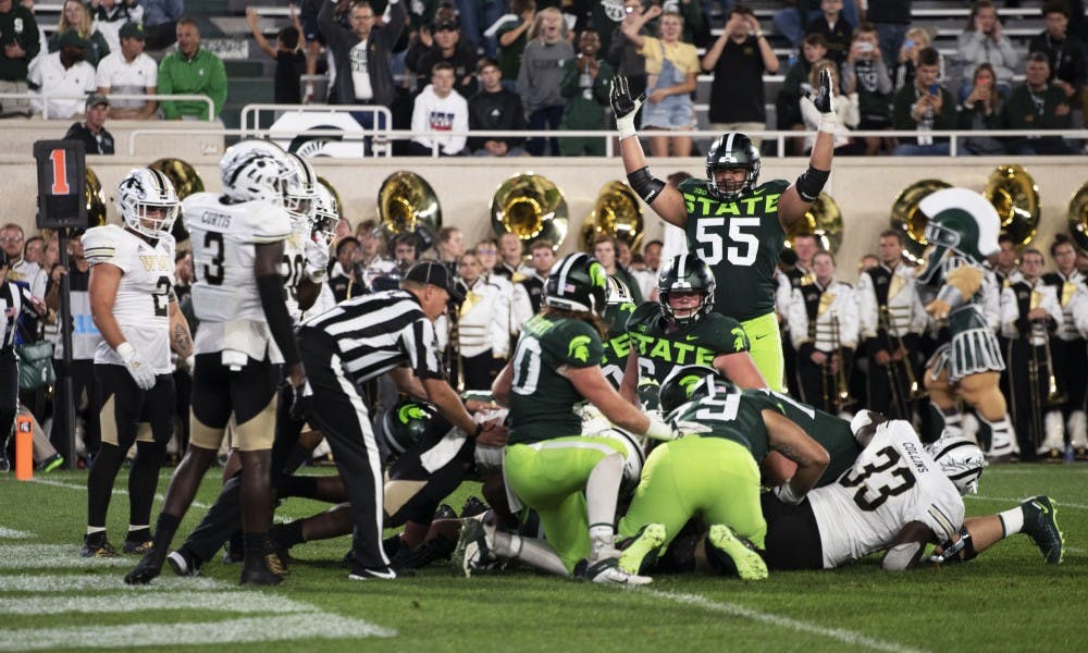 <p>Junior offensive tackle Jordan Reid (55) signifies a touchdown after tackling Western Michigan players. The Spartans crushed the Broncos (51-17) at Spartan Stadium on Sept. 7, 2019. </p>