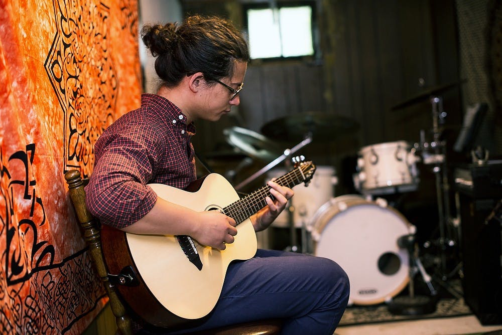<p>Jazz senior Kim Vi practices June 25, 2014, at his home in East Lansing. Kim Vi is the lead singer for his band Kim Vi and The Siblings. Hayden Fennoy/The State News</p>