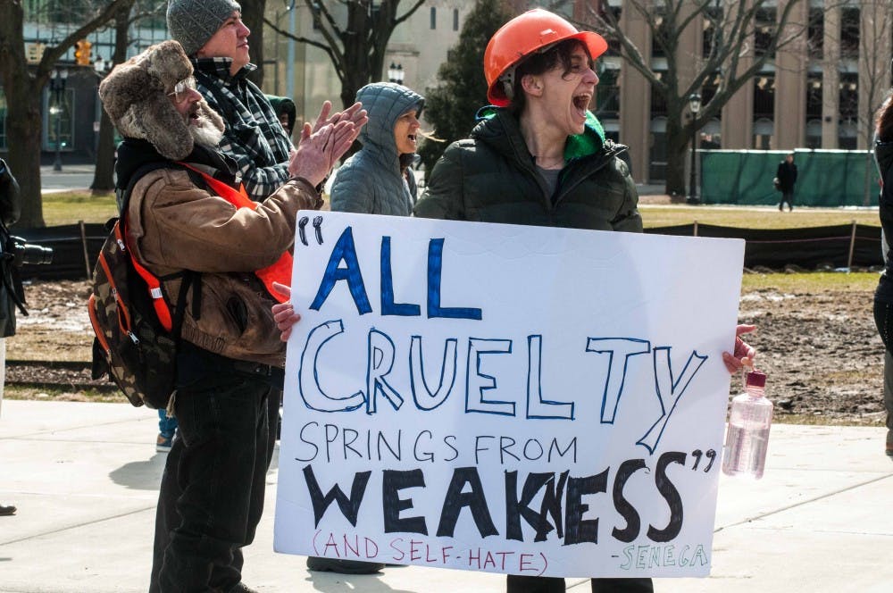 <p>Lansing Resident Kate Holloway holds a sign with a quote that reads "All cruelty springs from weakness (and self-hate) - Senga" at the Students Demand Action Rally on March 14, 2018 at the Michigan State Capitol. (Annie Barker | State News)</p>