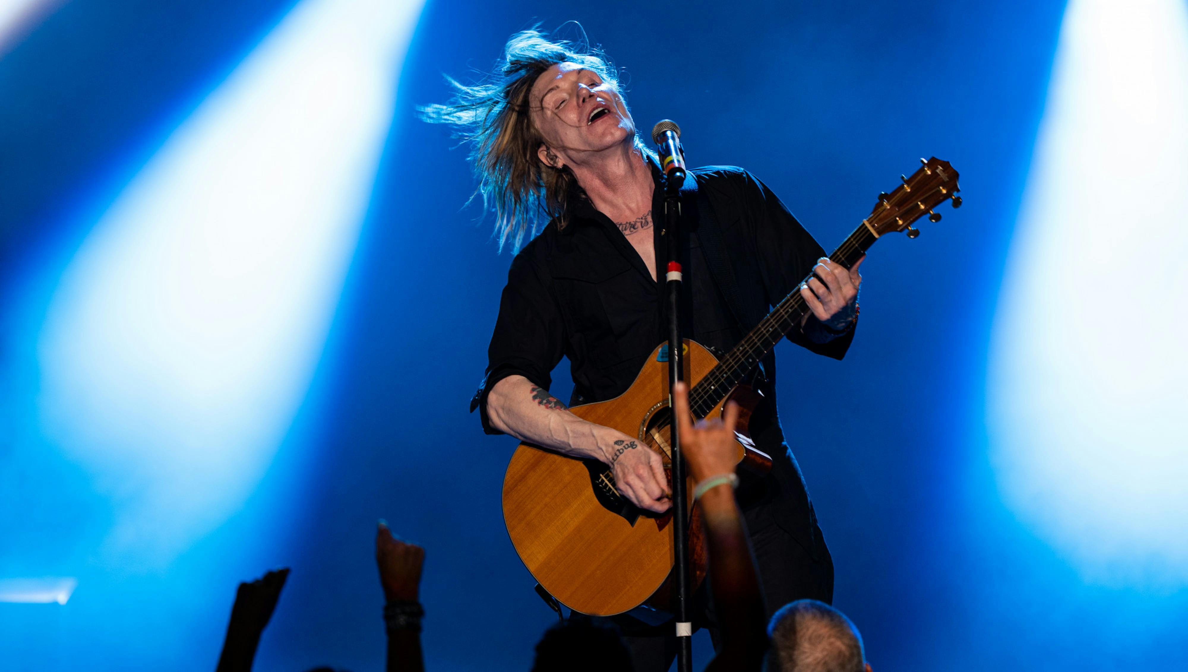 John Rzeznik flips his hair during the Goo Goo Dolls' concert at the Michigan Lottery Ampitheatre in Stearling Heights on Aug. 7, 2022.