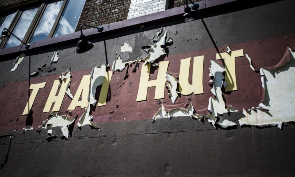 <p>The "Thai Hut" sign hanging at the corner of Grand River Ave. and Abbot Road, pictured on June 6, 2017. The building will be part of the Park District redevelopment project.</p>