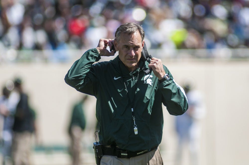 Head coach Mark Dantonio walks off the field during the Green and White scrimmage on April 23, 2015 at Spartan Stadium. The White team defeated the Green team, 14-11.