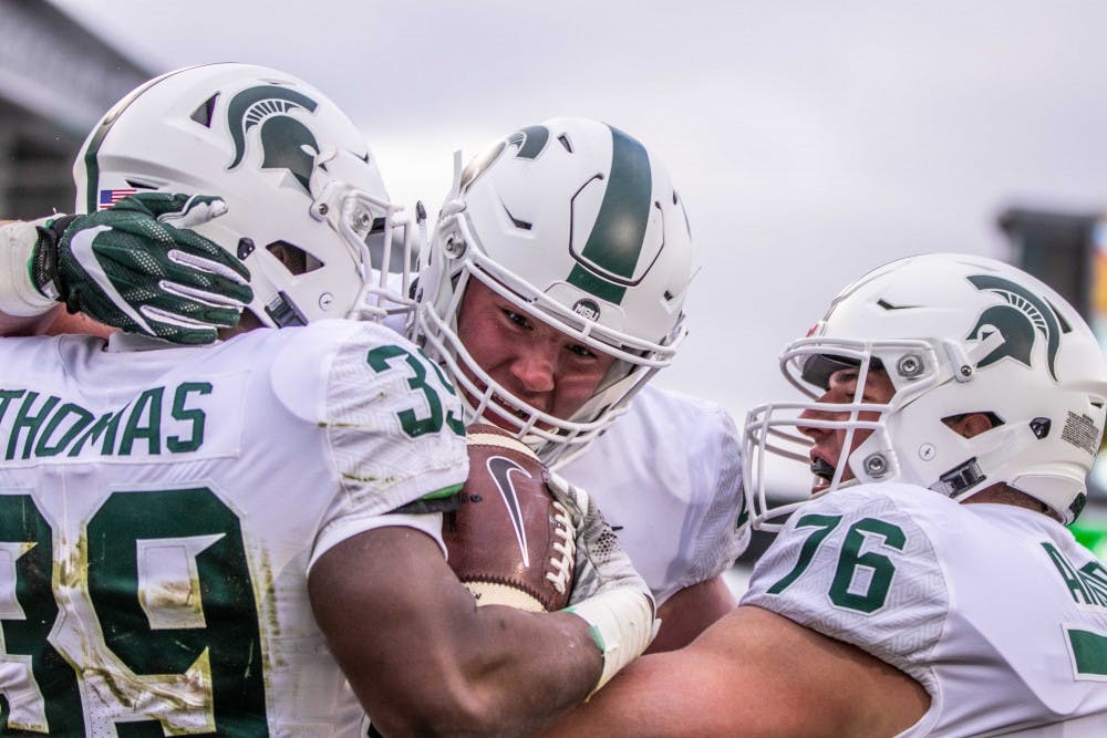 Redshirt sophomore running back Alante Thomas (39) celebrates a touchdown with  senior fullback Ben Line (45) and redshirt sophomore offensive tackle AJ Arcuri (76) during the annual Green and White spring game on April 7, 2018 at Spartan Stadium. White defeated Green, 32-30.