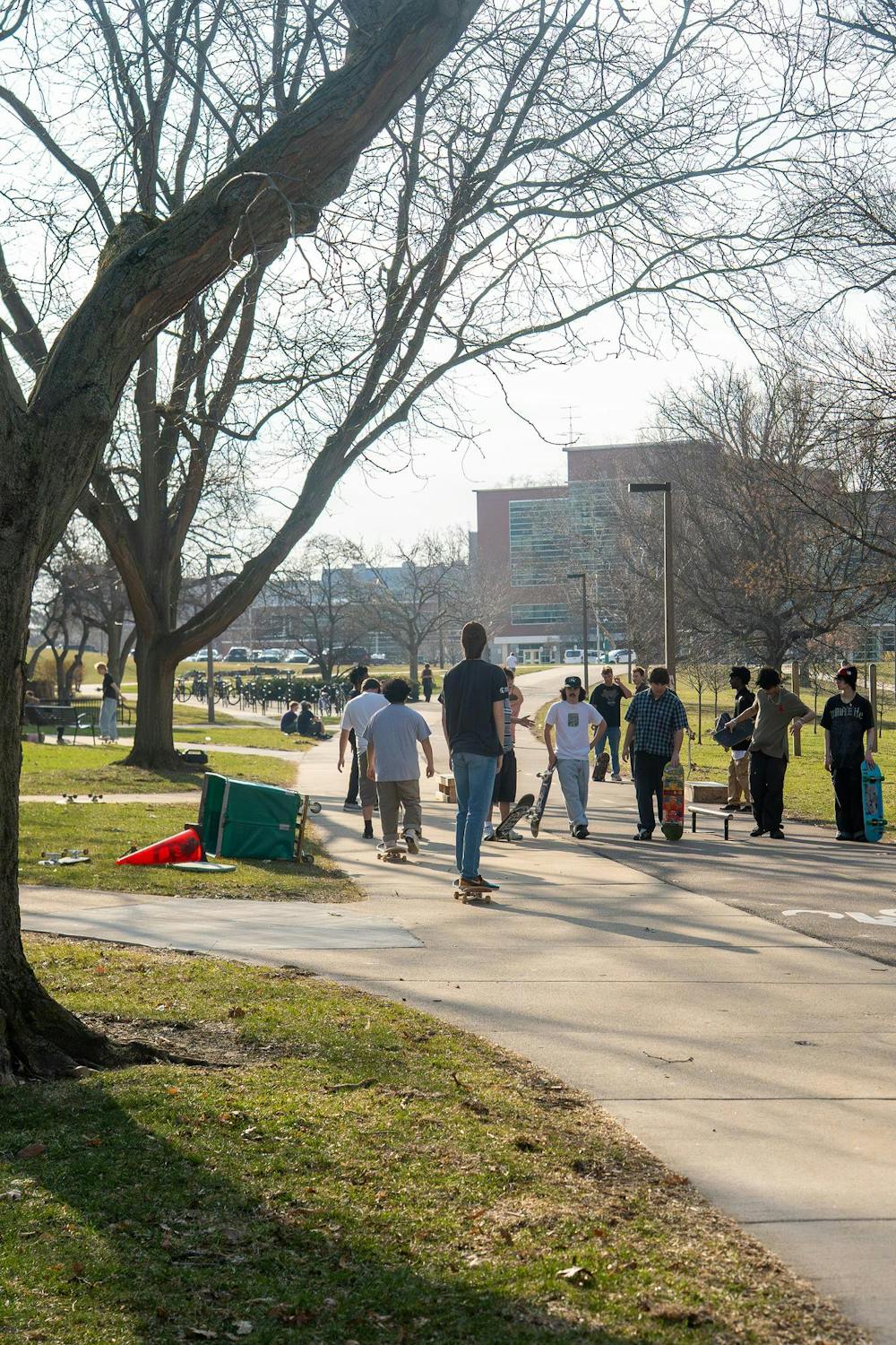 Members of MSU Skate Club talk and wait as others take turns practicing tricks during skate club outside of Shaw Hall on Michigan State University’s campus in East Lansing, Mich., on March 20, 2026.